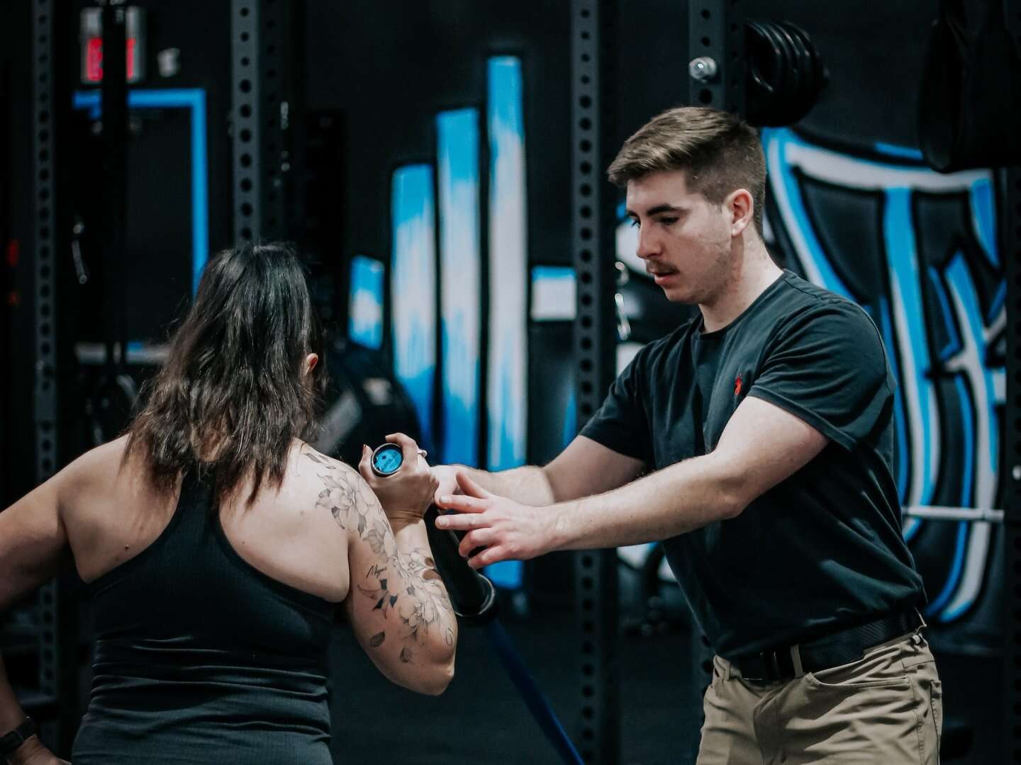 A BPM trainer coaching a member through band work