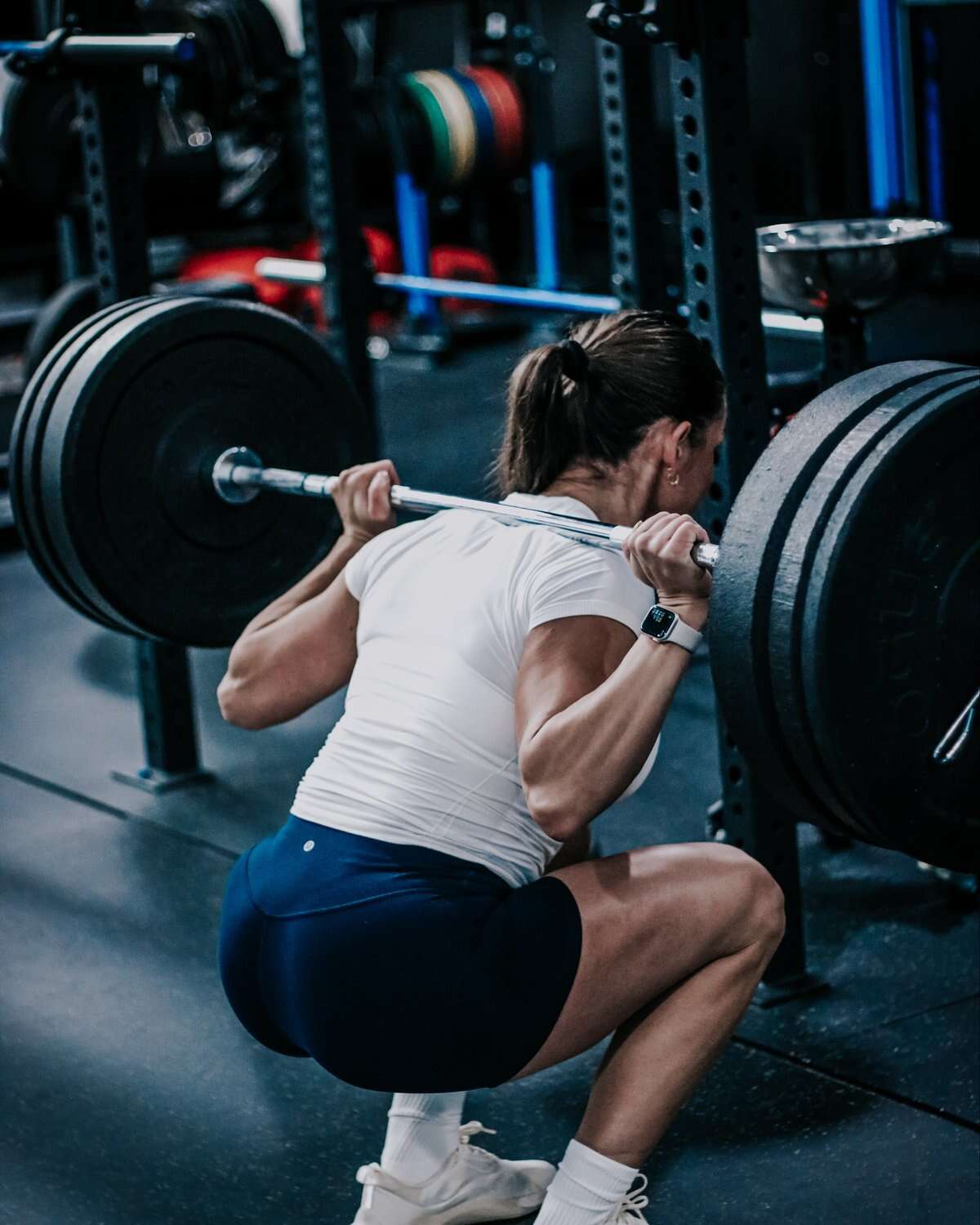 A member under the bar in a barbell back squat