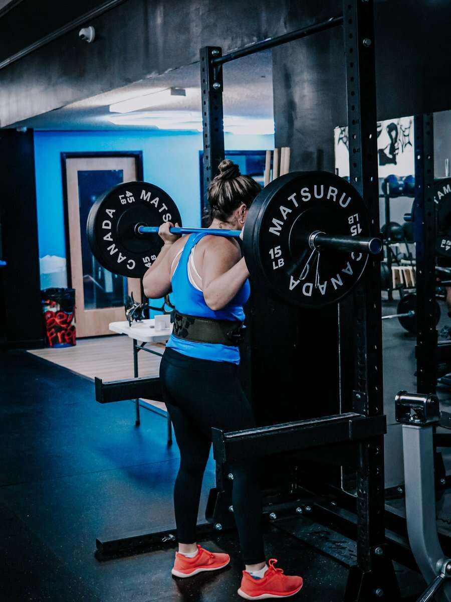 A back squat under the blue lights